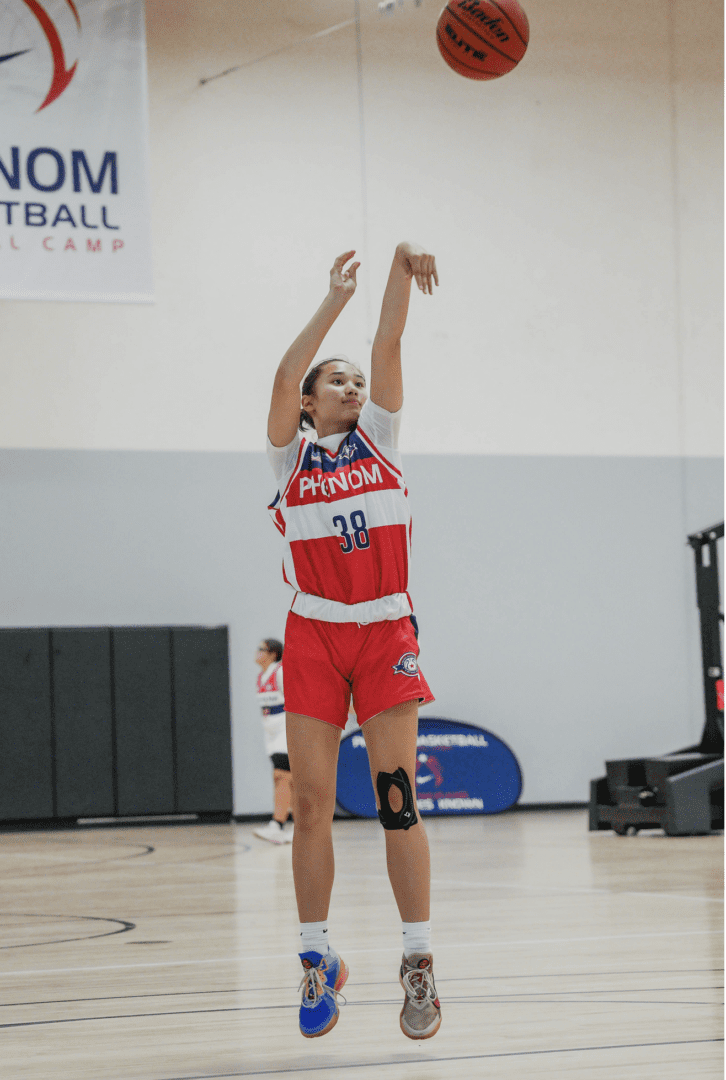 Female basketball player shooting a jump shot during a game.