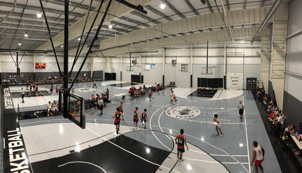Youth basketball game in a modern indoor gymnasium.