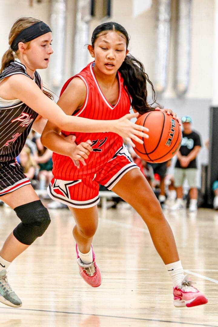 Girl dribbling basketball during a game.