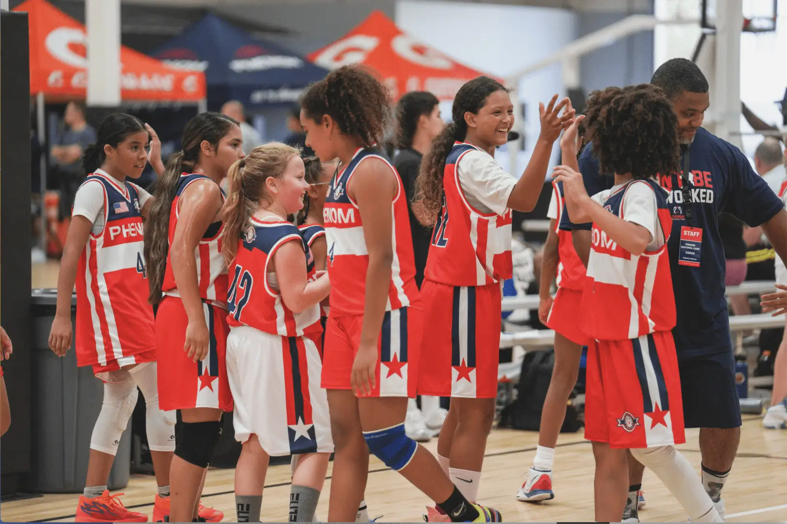 Young basketball players line up for high-fives after a game.