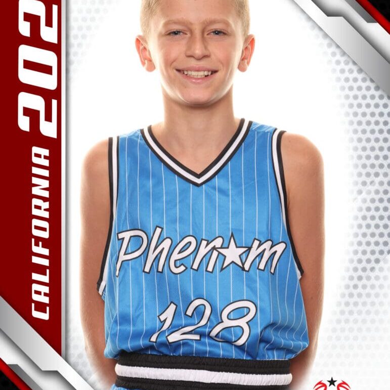 Young basketball player in a blue Phenom jersey smiling at the camera.