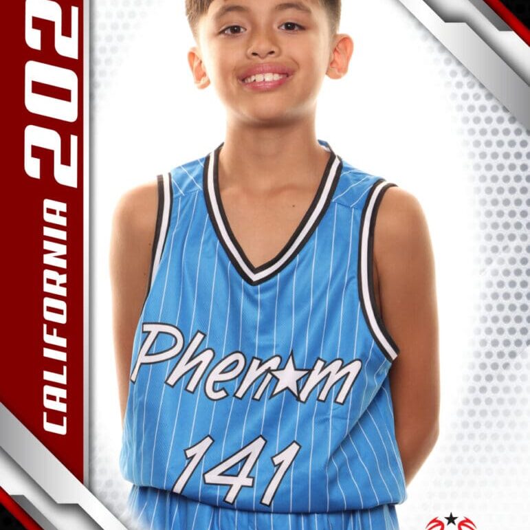 Young basketball player in a blue jersey smiling for a photo.
