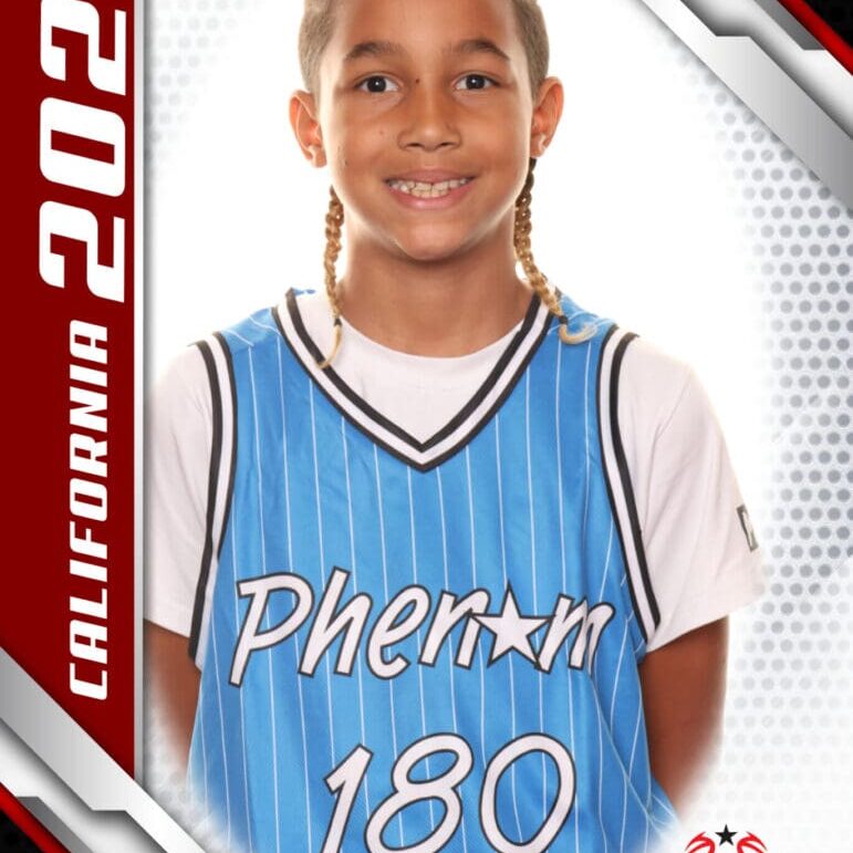 Young basketball player in a blue jersey smiling at the camera.