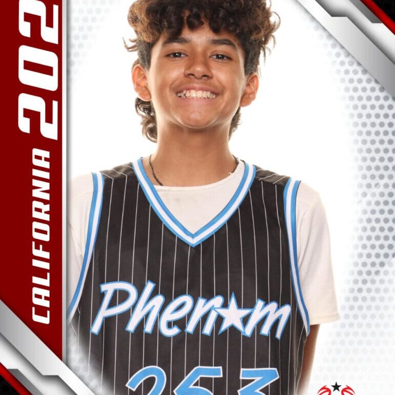 Young basketball player in a Phenom jersey smiling confidently.