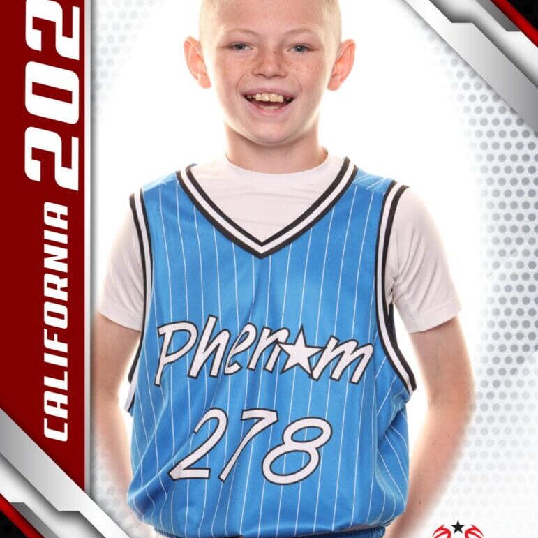 Young boy in blue basketball jersey smiling for a sports photo.