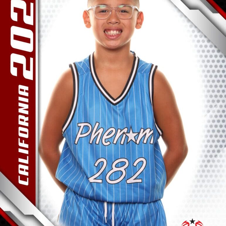Young basketball player in blue jersey smiling for a portrait.
