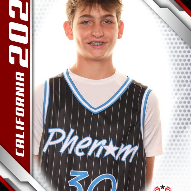 Young basketball player in a Phenom jersey smiling.