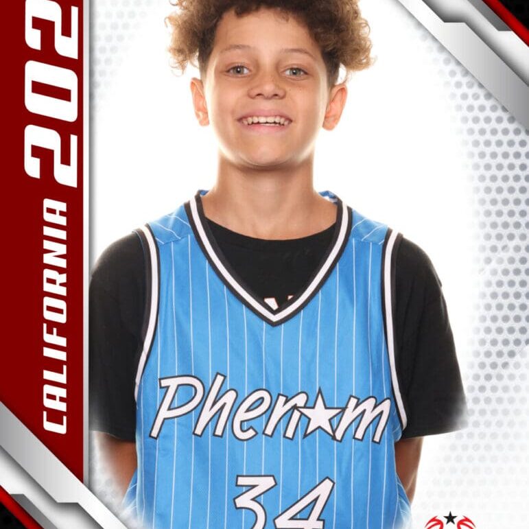 Young basketball player in a blue Phenom jersey smiling confidently.