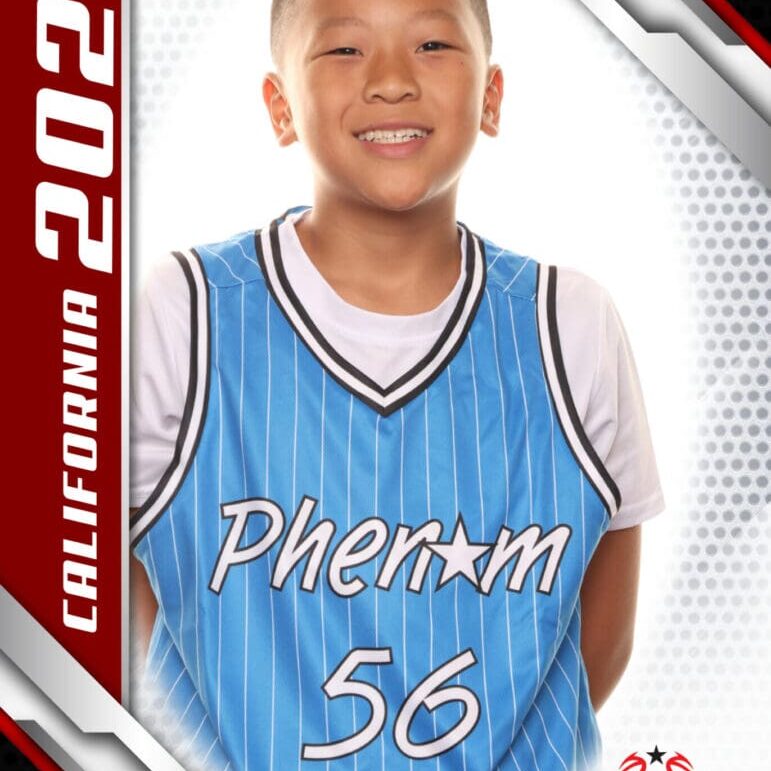 Young basketball player in blue jersey smiling for a photo.