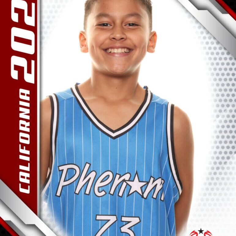 Young basketball player in blue jersey smiling for a photo.